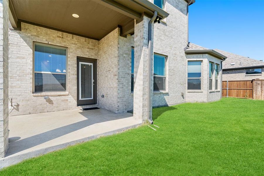 Doorway to property with a yard and a patio area