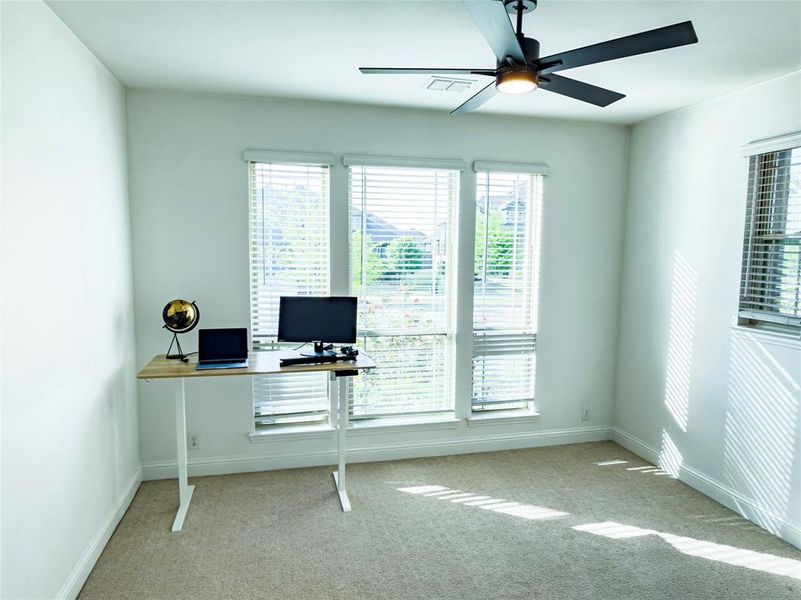 Office area featuring ceiling fan and light colored carpet