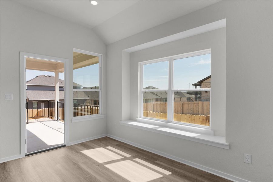 Empty room featuring light wood-style flooring and lofted ceiling