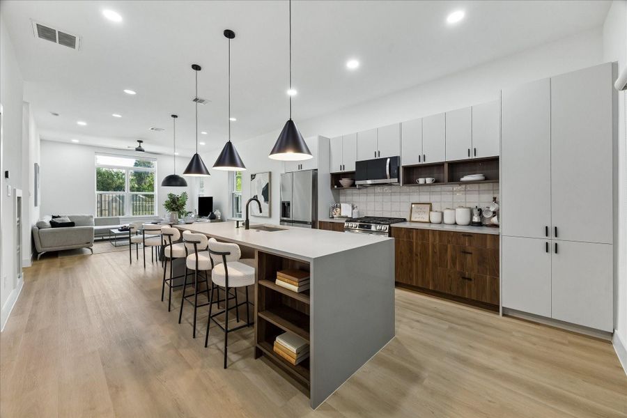 Large island, abundant cabinetry, and open shelving combine style with everyday functionality. The open layout keeps everyone connected, making this an ideal space for entertaining or everyday living.