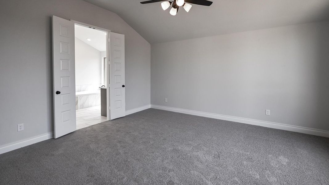 Unfurnished bedroom featuring baseboards, lofted ceiling, dark carpet, and a ceiling fan Unfurnished bedroom featuring baseboards, lofted ceiling, dark carpet, and a ceiling fan