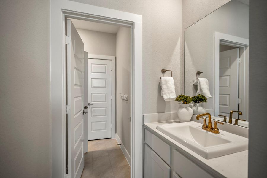 Each upstairs bedroom enjoys its own private vanity area, while a shared water closet with tub and shower combination keeps the Hollywood-style bathroom practical and easy to share.