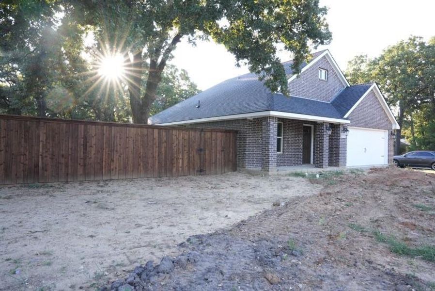 View of side of property with a shingled roof, brick siding, and an attached garage View of side of property with a shingled roof, brick siding, and an attached garage