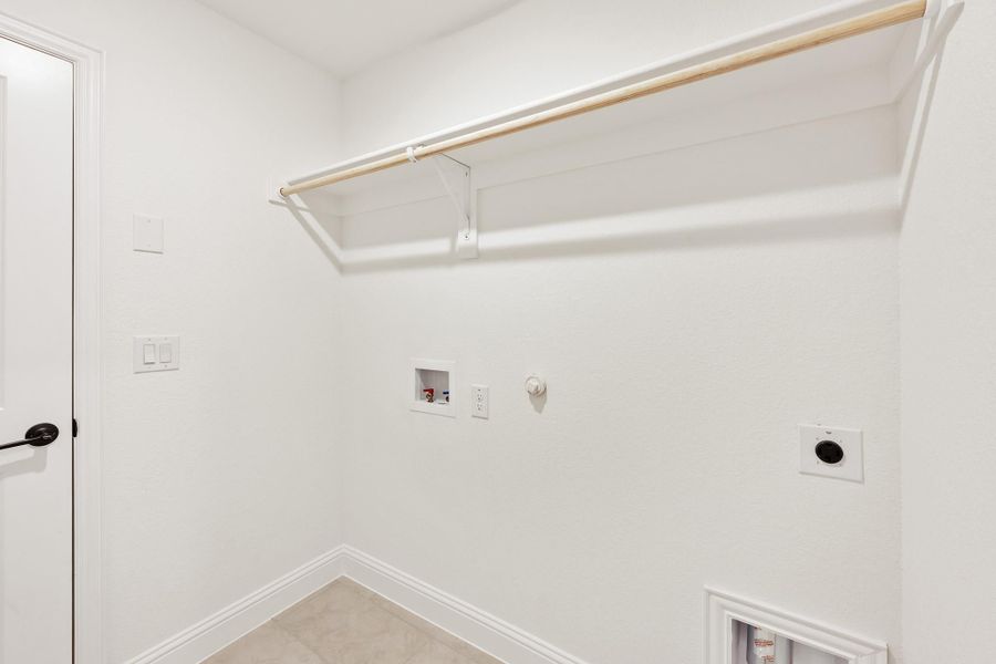 Laundry room with wall-mounted hanging rod, washer and dryer hookups, and white walls Laundry room with wall-mounted hanging rod, washer and dryer hookups, and white walls
