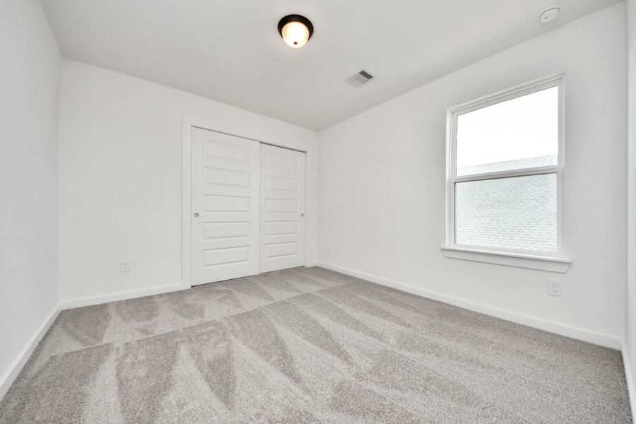 Secondary bedroom features plush carpeting, large windows that let in plenty of natural light, bright paint, and spacious closets. Secondary bedroom features plush carpeting, large windows that let in plenty of natural light, bright paint, and spacious closets.