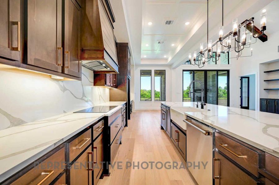 Kitchen with light wood-style floors, light stone counters, stainless steel dishwasher, custom exhaust hood, and recessed lighting Kitchen with light wood-style floors, light stone counters, stainless steel dishwasher, custom exhaust hood, and recessed lighting