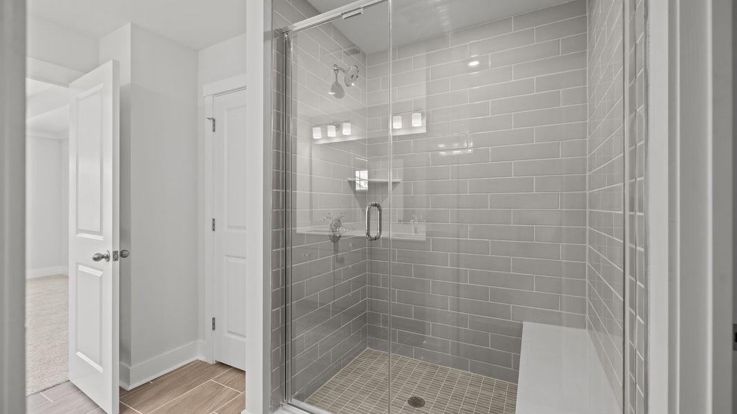 Burton Design fully-tiled shower with seat and premium finishes. At Lakeside Glen by DRB Homes in York, SC.