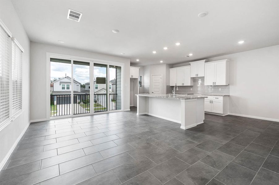 View of the kitchen and formal dining with large sliding doors for the outdoor patio. View of the kitchen and formal dining with large sliding doors for the outdoor patio.