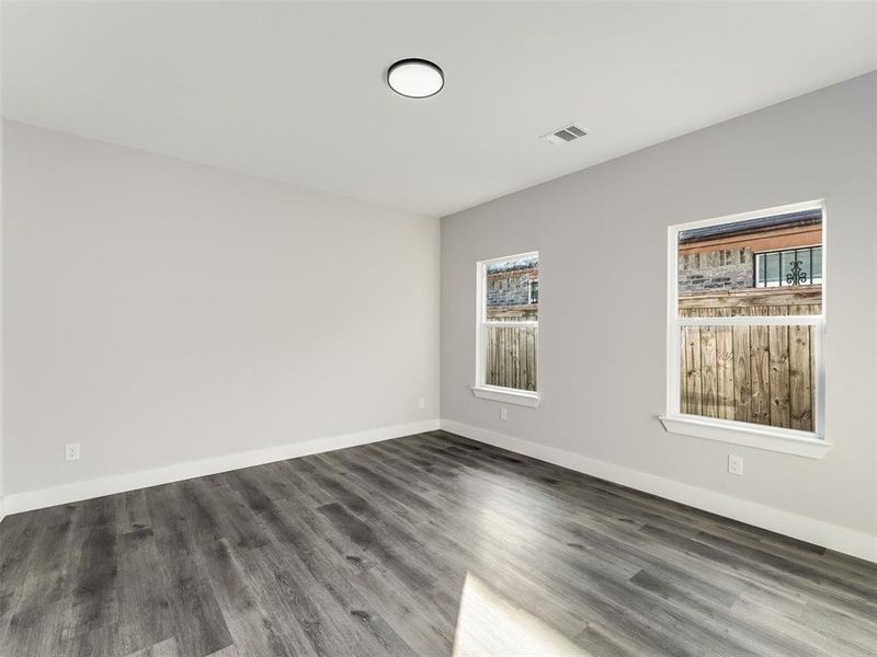 Unfurnished room with plenty of natural light and dark wood-type flooring