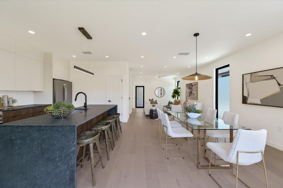 Dining area with light wood finished floors and recessed lighting