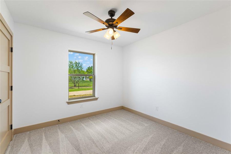 Spare room featuring light carpet and ceiling fan