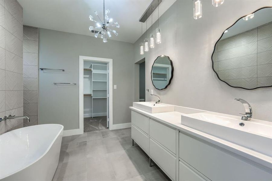 Bathroom with vanity, a tub, and an inviting chandelier