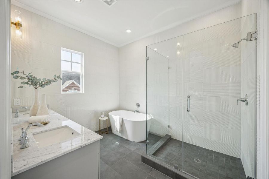 Primary suite - has frameless shower, free-standing tub and tiled walls.