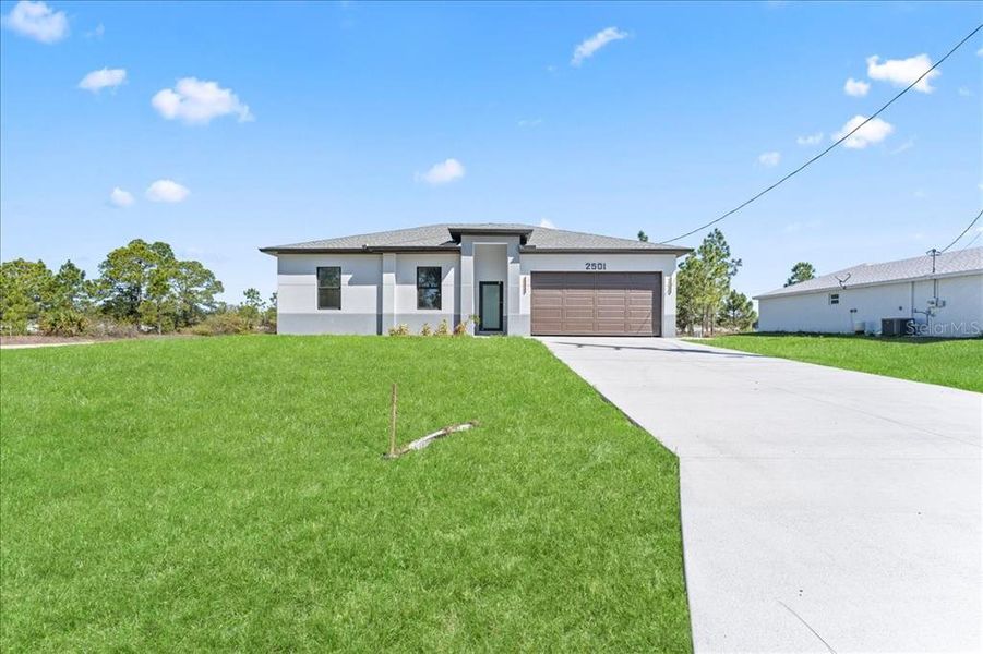 Front exterior of a new home in , Lehigh Acres, FL, highlighting curb appeal (Image 7).