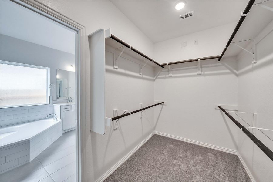 Walk in closet featuring light carpet Walk in closet featuring light carpet