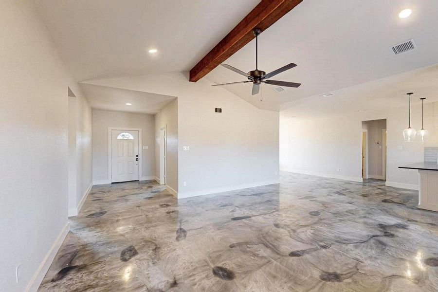 Unfurnished living room with vaulted ceiling with beams, marble finish floor, ceiling fan, and baseboards