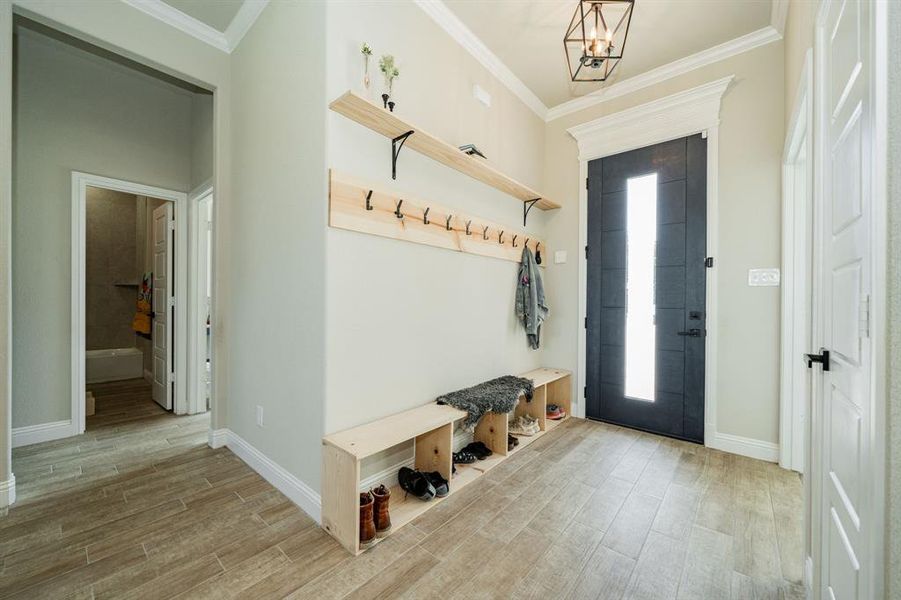 Mudroom featuring crown molding and wood tiled floors Mudroom featuring crown molding and wood tiled floors