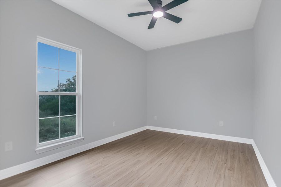 Unfurnished room featuring light wood-style flooring and ceiling fan