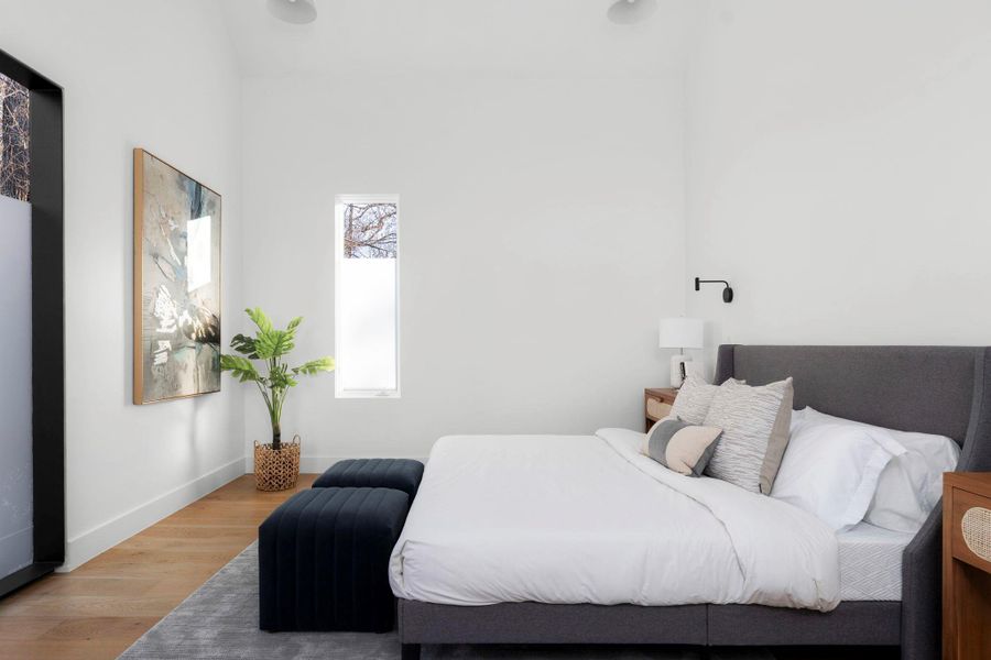 Bedroom with wood finished floors and baseboards