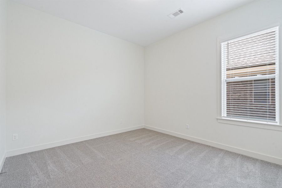 Spare room with light carpet and baseboards