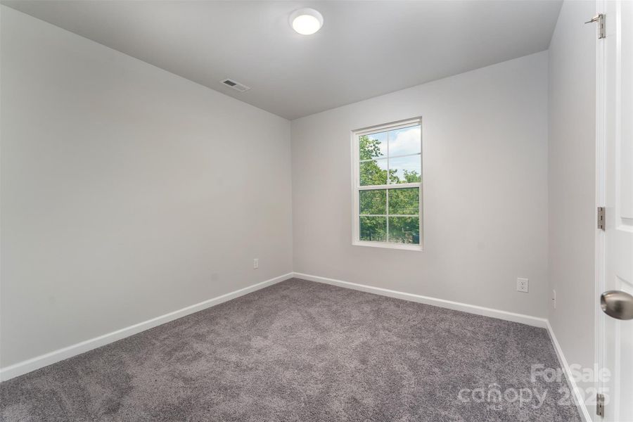bedroom #2 looks out to the wooded backyard
