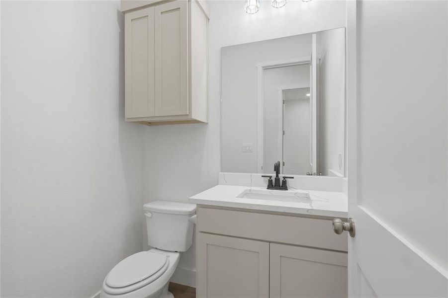 Bathroom vanity featuring a light-colored countertop with integrated sink, matte black faucet, and a large mirror