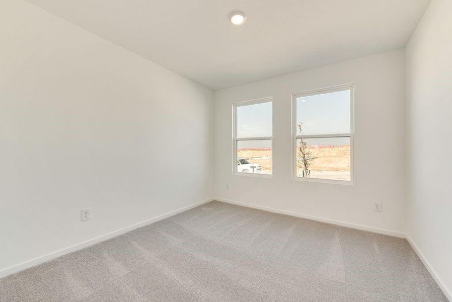 Empty room featuring baseboards and light colored carpet