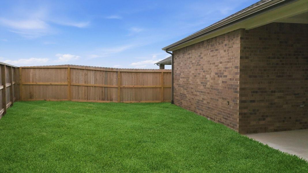 Large fenced-in backyard with a covered patio, perfect for outdoor entertaining. Large fenced-in backyard with a covered patio, perfect for outdoor entertaining.