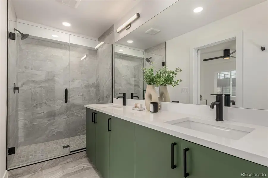 Primary bath with double vanities, spa shower, and separate toilet room