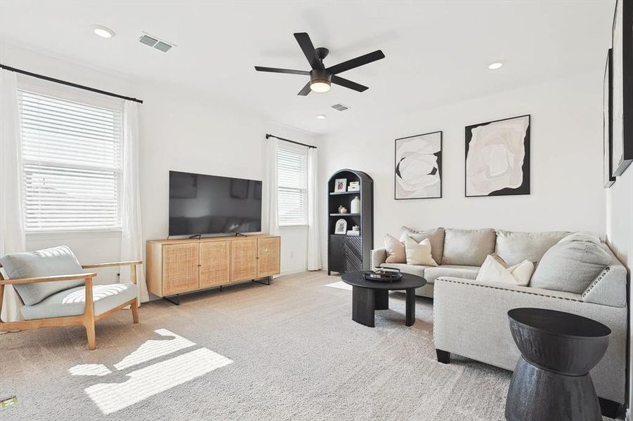 Carpeted living room featuring ceiling fan