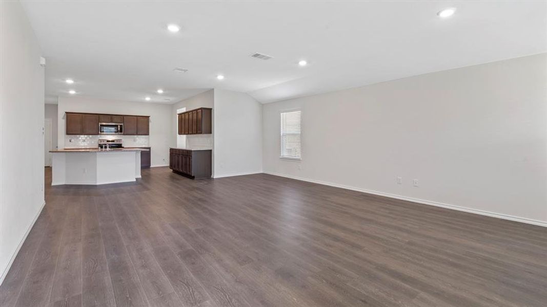 Unfurnished living room with recessed lighting and dark wood-style floors