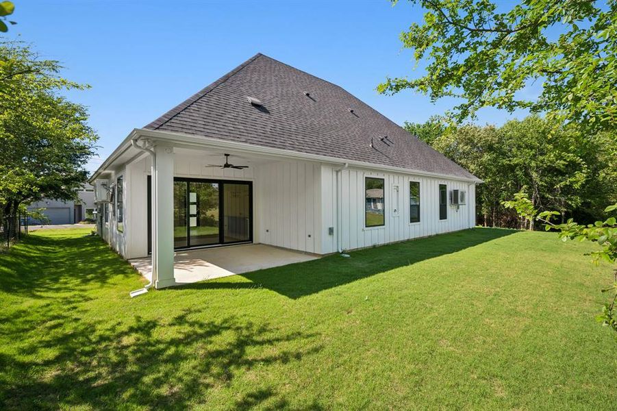 Back of house featuring a patio area with ceiling fan and large yard.