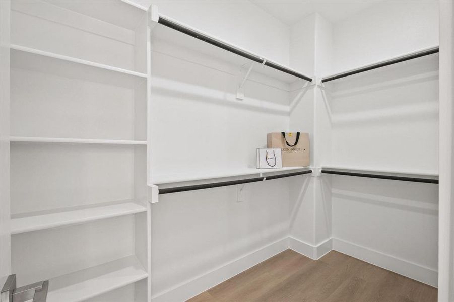 Spacious closet featuring light wood-style flooring