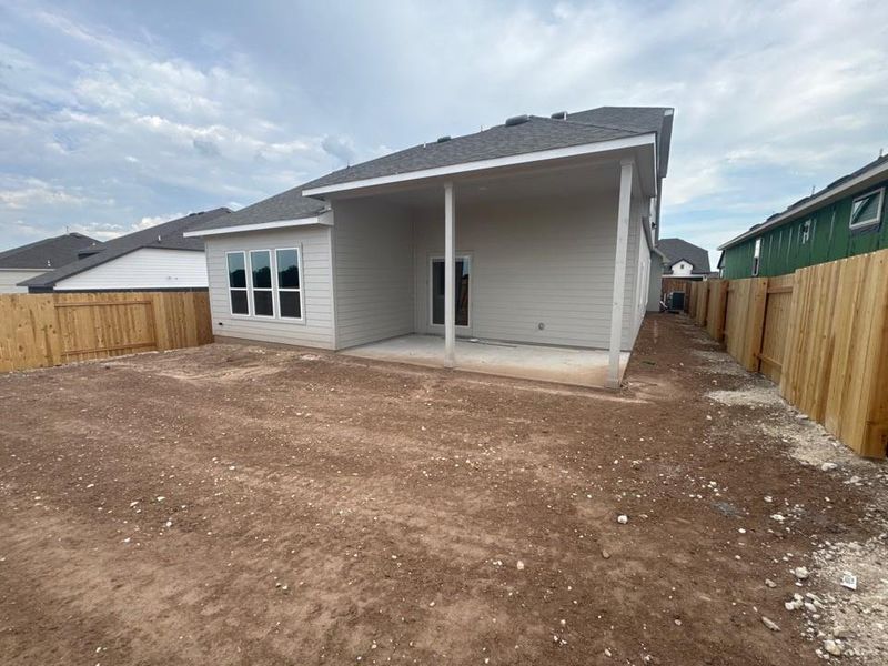 Back of house with a patio, a fenced backyard, and roof with shingles