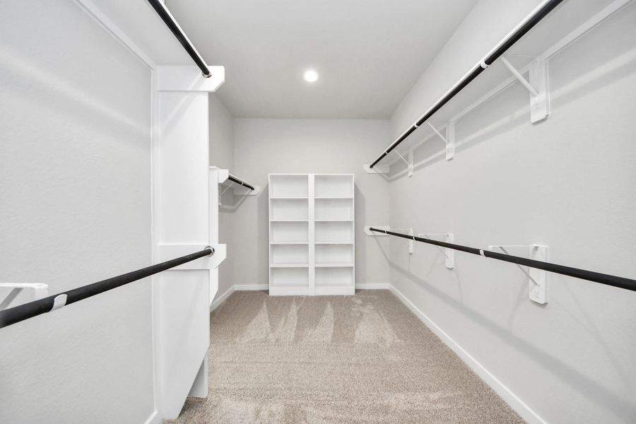 Walk-in closet that epitomizes luxury and practicality. This generously sized space features built-in shelving, offering abundant room for impeccable organization. High ceilings and recessed lighting create a bright and welcoming ambiance.