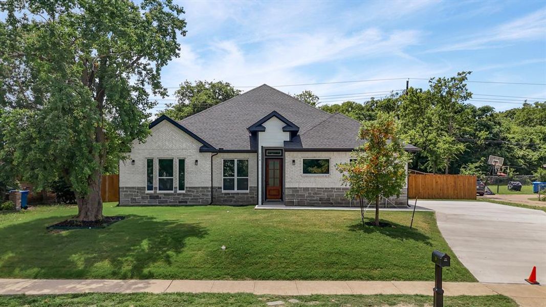 French country home with stone siding, a shingled roof, and concrete driveway French country home with stone siding, a shingled roof, and concrete driveway