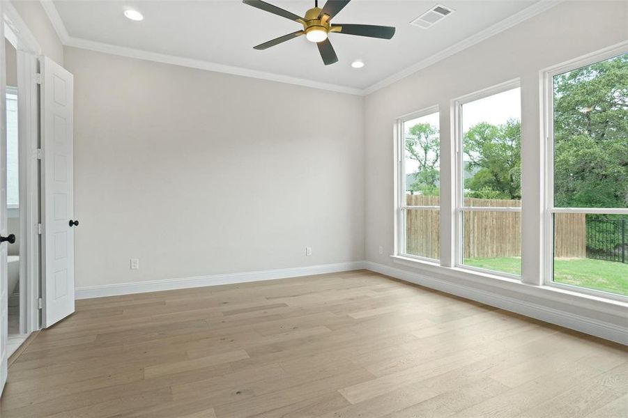 Empty room featuring light wood-type flooring and plenty of natural light