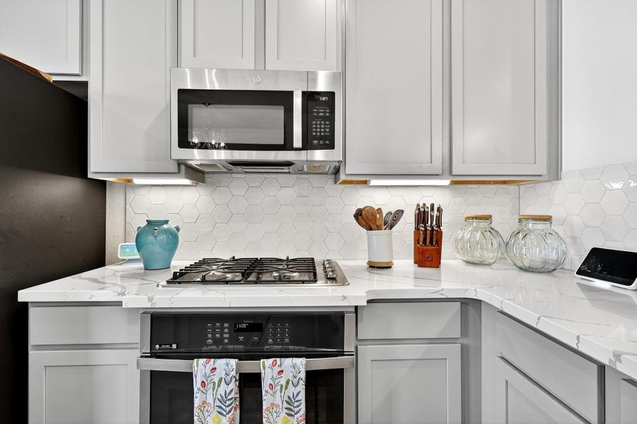 Sleek design highlighted by a hexagon tile backsplash, gas range, and modern finishes for a refined contemporary feel. Sleek design highlighted by a hexagon tile backsplash, gas range, and modern finishes for a refined contemporary feel.