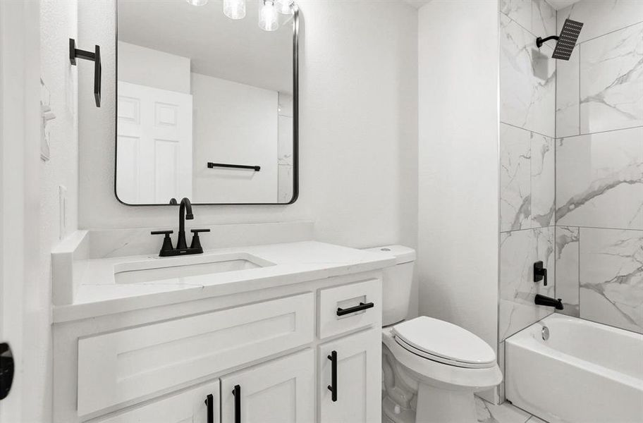 Contemporary bathroom featuring a white vanity with a rectangular undermount sink, quartz countertop, and matte black fixtures Contemporary bathroom featuring a white vanity with a rectangular undermount sink, quartz countertop, and matte black fixtures