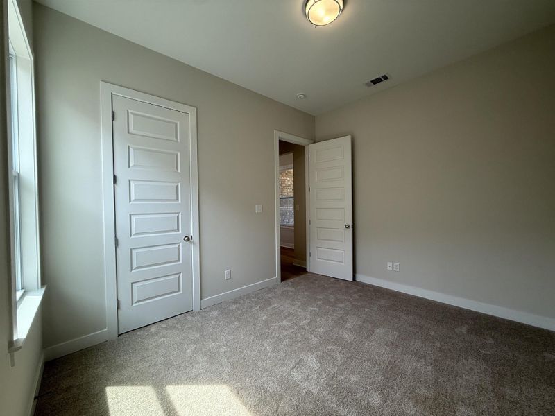 Unfurnished bedroom featuring carpet and baseboards