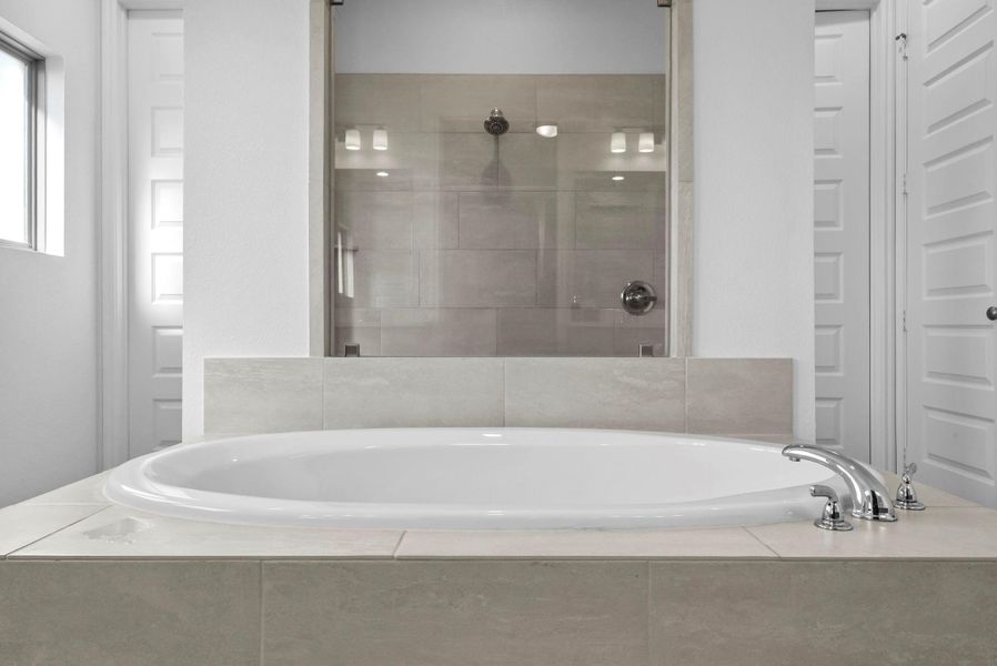 Full bathroom featuring a shower stall and a bath