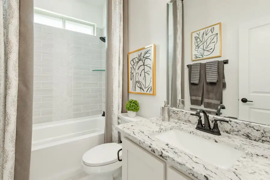 Full bathroom with granite vanity, tiled tub-shower combo, and white cabinets