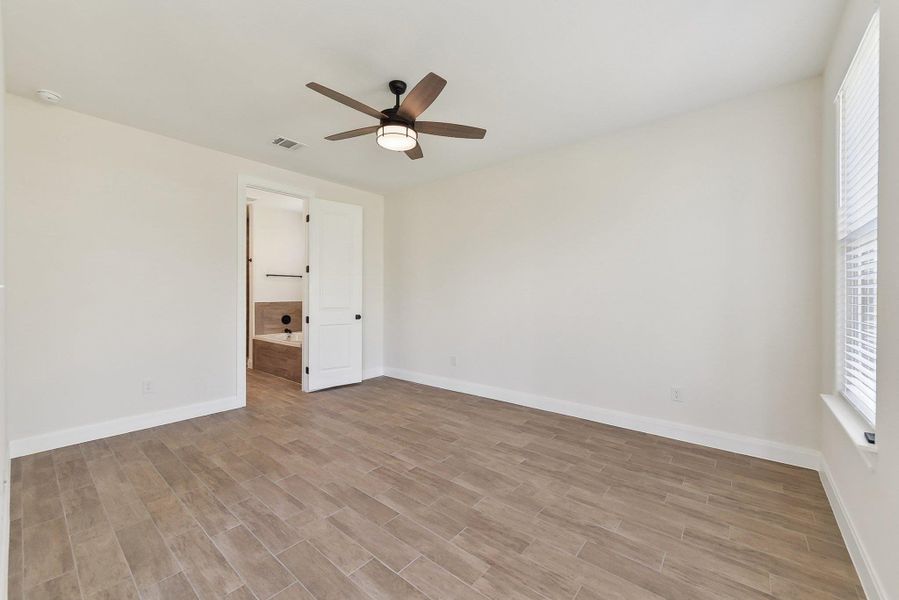 Unfurnished room with visible vents, baseboards, light wood-style floors, and ceiling fan