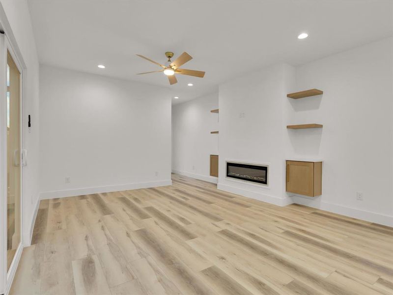 Unfurnished living room featuring ceiling fan and light wood-type flooring