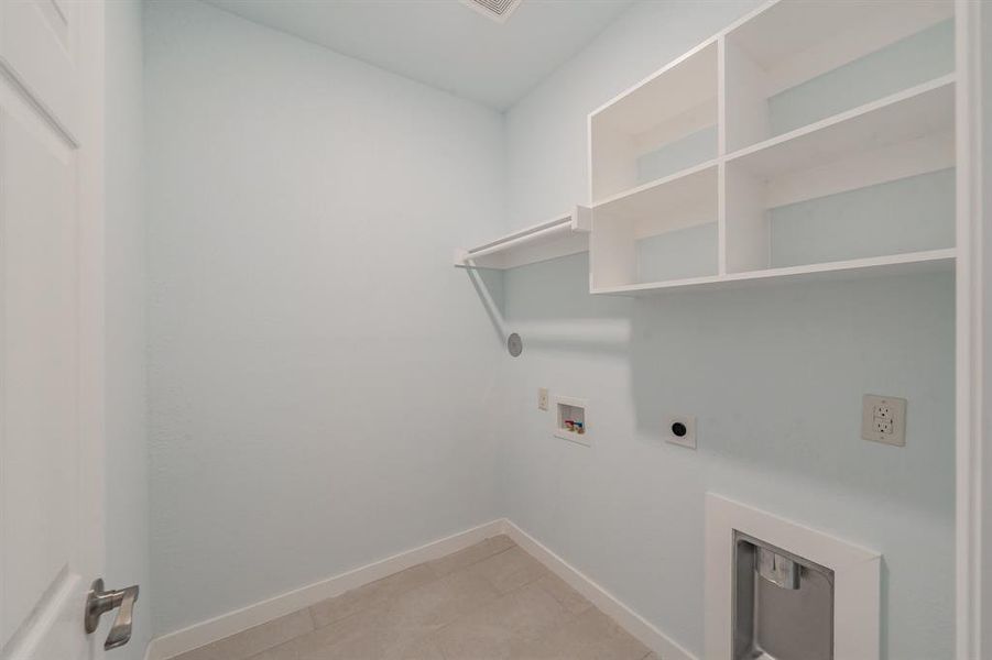 Laundry room featuring hookup for an electric dryer, washer hookup, and light tile patterned flooring Laundry room featuring hookup for an electric dryer, washer hookup, and light tile patterned flooring