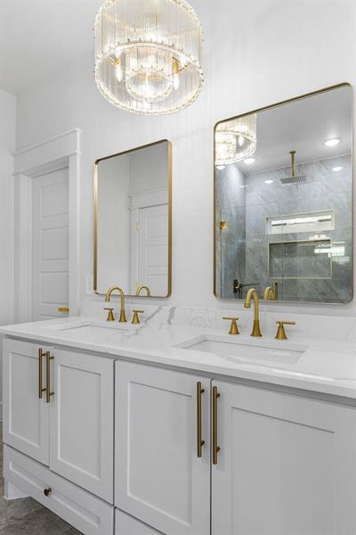 Bathroom featuring vanity, a shower with shower door, and a chandelier