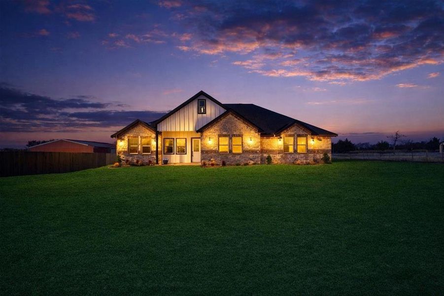 Stone and vertical siding exterior featuring a dark asphalt shingle roof Stone and vertical siding exterior featuring a dark asphalt shingle roof