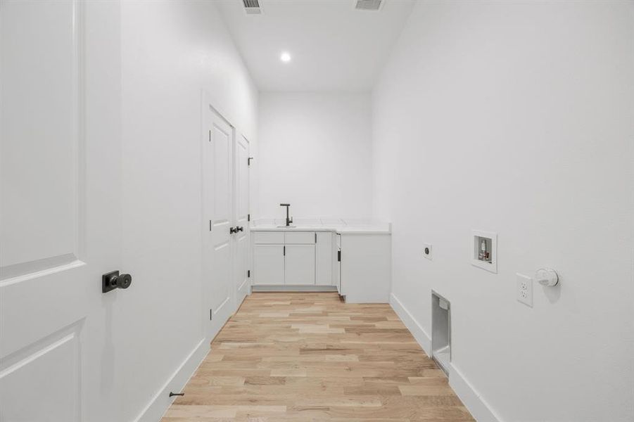 The spacious laundry room offers exceptional convenience with direct access to the primary bedroom closet and features ample cabinetry, quartz countertops, and a utility sink. Designed for functionality, the space provides plenty of room for side-by-side washer and dryer appliances. The spacious laundry room offers exceptional convenience with direct access to the primary bedroom closet and features ample cabinetry, quartz countertops, and a utility sink. Designed for functionality, the space provides plenty of room for side-by-side washer and dryer appliances.