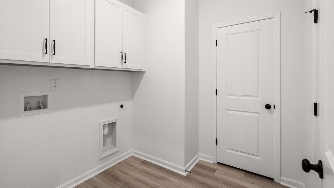 The Easton plan laundry room provides storage cabinets and space for washer and dryer.