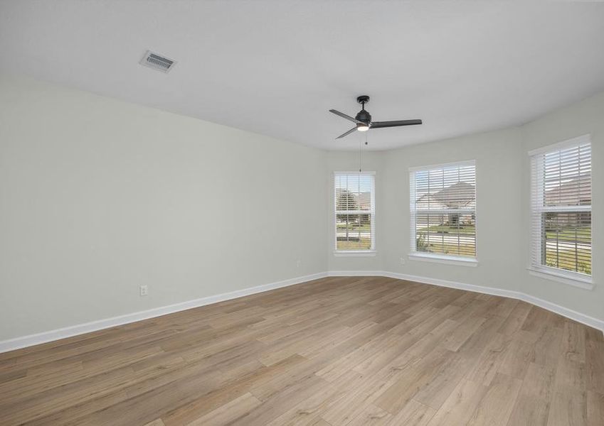 The master bedroom has plank flooring and three beautiful bay windows.